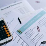 Tax preparation setup with documents, smartphone calculator, and checklist.